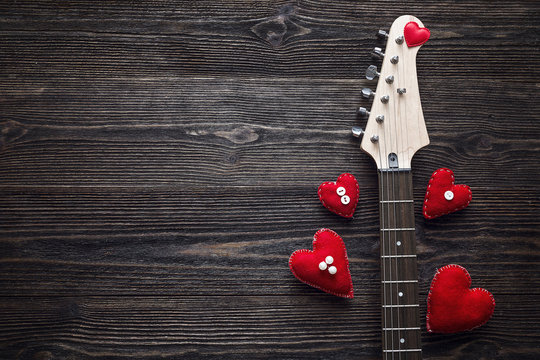 Neck Electric Guitar with hearts on a dark wooden background. Sp