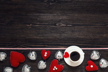 Border from Valentine hearts and cup of coffee on the dark woode