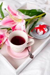 tray with cup of hot tea in the bed,