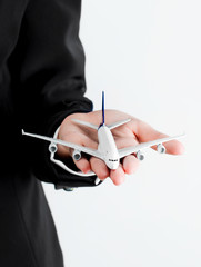 A plane model on a business woman's hand, Isolated on white background.
