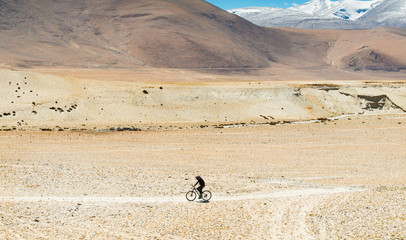 Fototapeta na wymiar young man cycling through the remote area on rugged road in the himalaya range,motion blur, soft focus
