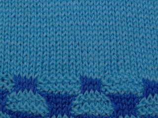 текстура вязаной ткани с синим рисункам       
