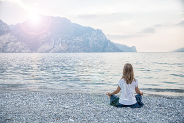 Naklejka na ściany i meble Woman meditating at the lake