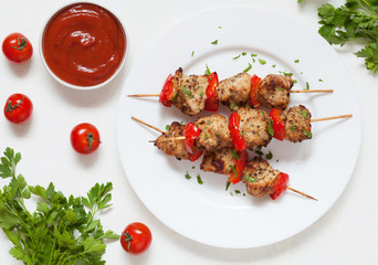 Traditional delicious turkey or chicken shish kebab skewer barbecue meat with tomatoes, pepper and sauce. Served on white kitchen table background. Natural light. Picnic bbq gourmet.