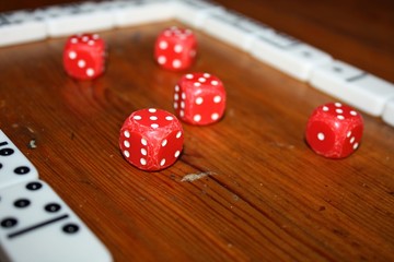 Classic red poker dices close up on wooden brown background with domino game frame