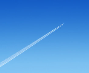airplane high in the blue sky