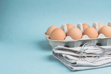 Eggs and ingredients for baking on a light green background