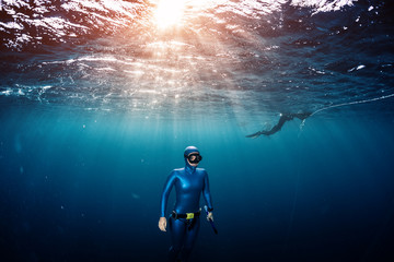 Woman free diver ascending from the depth in a tropical clear sea