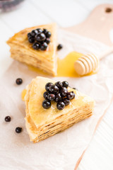 Homemade pancakes with berries and honey on a white background