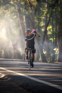 Cyclist drinking from a bottle while riding a bicycle