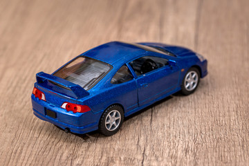Fototapeta na wymiar Classic blue model toy car on wooden desk.