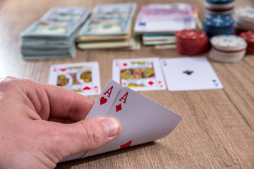 man holding play card. poker chips, us dollar.