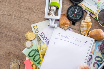 Summer holiday background - notebook with selfie stick, money, glasses, map, seashells, compass.