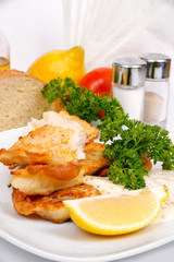 Perch in batter with herbs and spices on a white plate