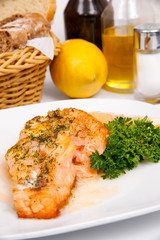 Salmon with shrimps and greens on a white plate