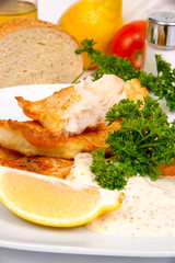 Perch in batter with herbs and spices on a white plate