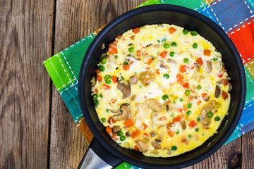 Omelet with vegetables in a pan