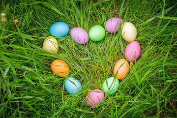 Fototapeta na wymiar background with colorful easter eggs on lawn in heart shape