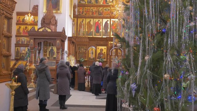 a Lot of Parish People in a Christian Church, Standing and Praying in Front of a Huge Iconostasis With Icons, Wooden Columns Inside of a Orthodox Cathedral in Kiev