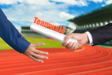 Cropped hand of businessman passing relay baton to colleague