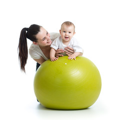 Fototapeta na wymiar young mother and her baby child doing yoga exercises on gymnastic ball isolated over white