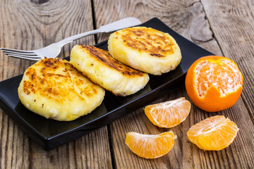 Hot sweet cheesecakes with tangerines and honey