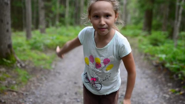Little girl child in summer forest running to the camera, stopping talking to you and showing welcoming gesture inviting to run together
