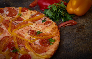 Pizza and different ingredients in it. Dark background. View from above. Studio photography, Subject photography.