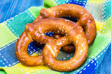 Freshly baked pretzels with salt and cheese on a blue background