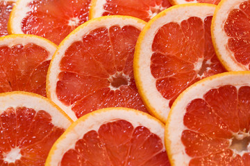 Bright red background with juicy slices of grapefruit. Healthy f
