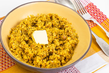 Lentil porridge with butter in a ceramic bowl on a white backgro
