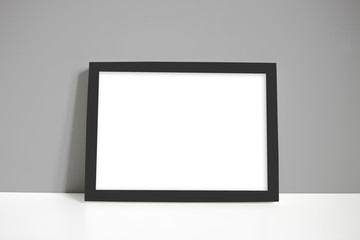 Black landscape frame against a grey wall