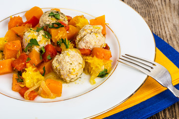 Ratatouille with meatballs on a white plate