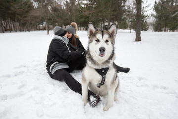 Beautiful family, a man and a girl in winter forest with dog. Pl