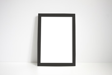 Black portrait frame against white wall