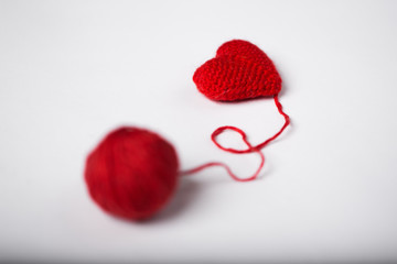 Close up of a wool ball and heart shape on white background. Hea