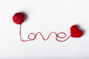 Close up of a wool ball and heart shape on white background. Hea