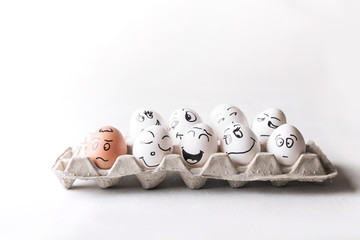 Eggs with funny faces in the package on a white background. Easter Concept Photo. Eggs. Faces on...