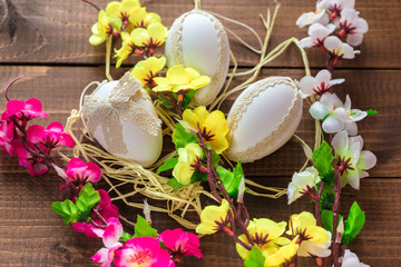 Beautiful Easter eggs with flowers on the wooden background