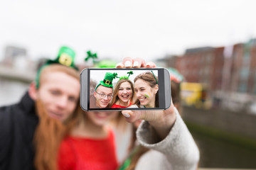 Group of Friends Taking a Picture with a Mobile Phone . St Patri
