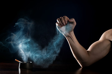 stop smoking concept. Human hand is struggling with a hand of smoke © Valerii