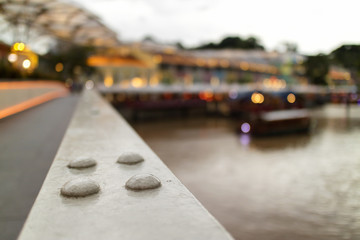 blurred background with bokeh of metal bridge and restaurant by river