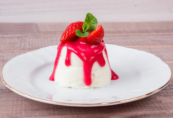 panna cotta dessert with strawberry sirup and mint leaf