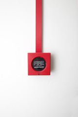 Red Push button Fire Alarm on white painted wall
