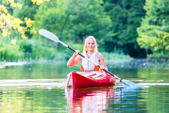 Woman driving with kayak on forest river