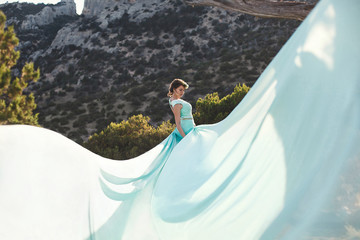 Bride in nature in the mountains near the water. Dress color Tif
