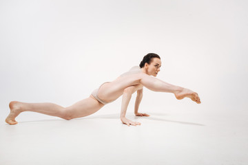 Fototapeta na wymiar Flexible young ballet dancer stretching in the studio
