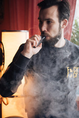 The young guy smoking vape, fashion with vape steam