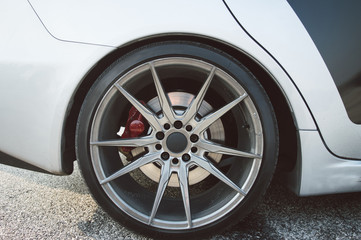 Sport car silver wheel close up view on white car.