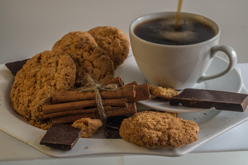 still life with pastry, chocolate and cinnamon, coffee poured into the Cup